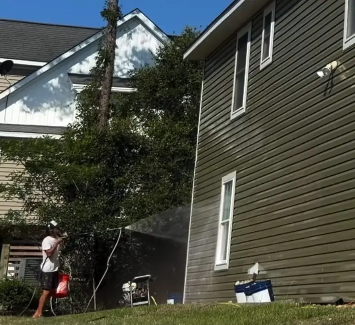 Top Shelf OBX technician soft washing a home exterior